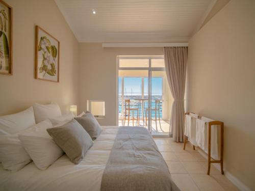 a bedroom with a bed with a view of the ocean at 9 Quarter Deck in St Francis Bay