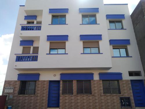 a white building with blue shutters on it at Hammadi's house in Oualidia