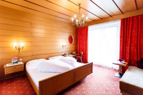a bedroom with a large bed with a wooden wall at Pension Rebgut in Lana
