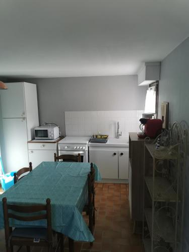 uma cozinha com uma mesa e uma cozinha com um fogão em Petite maison ploufragan em Ploufragan