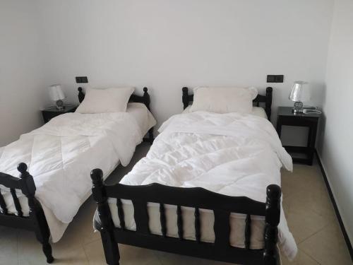 two beds sitting next to each other in a bedroom at Hammadi's house in Oualidia