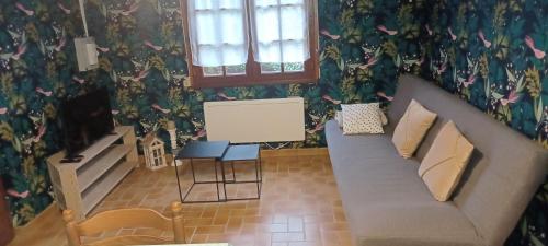uma sala de estar com um sofá e uma mesa em Petite maison ploufragan em Ploufragan