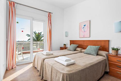 a bedroom with a bed with two towels on it at Villas Calan Bosch Emily in Cala'n Bosch