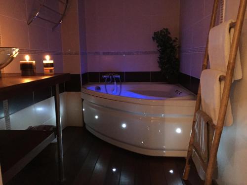 a bathroom with a tub and a table and candles at Appartement Esterelle in Cassis