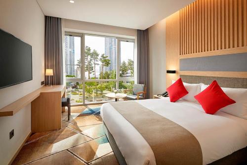a hotel room with a large bed with red pillows at Staz Hotel Premier Dongtan in Hwaseong