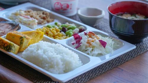 a tray of food with rice and vegetables on a table at Hotel Grand View Fukuoka-Kuko in Fukuoka