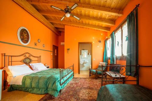 una camera da letto con pareti arancioni, un letto e un soffitto di Le Mistral a Sommacampagna