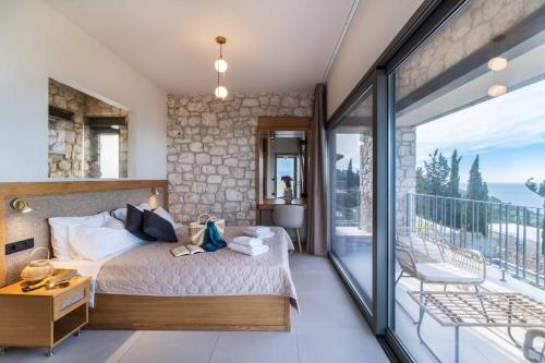 a bedroom with a bed and a balcony at Villa Orion in Tsoukaladhes