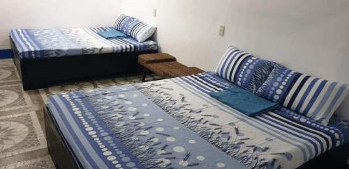 Habitación con 2 camas y sofá con almohadas en Spacious Resort in Pansol up to 20 pax, en Pansol