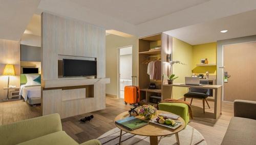 a living room with a couch and a tv at KHAS Gresik in Gresik