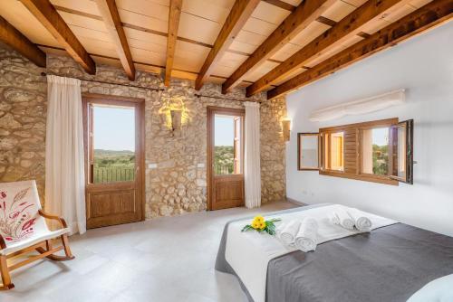 a bedroom with a bed and a stone wall at Sa Serra in Sant Joan