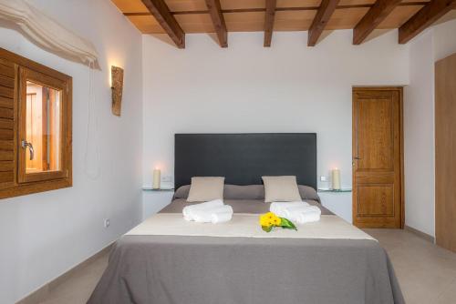 a bedroom with a large bed with two towels on it at Sa Serra in Sant Joan