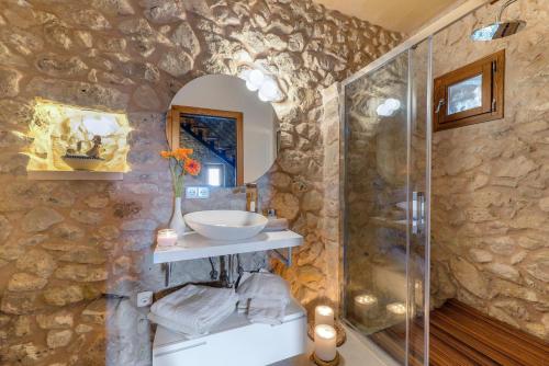 un bagno in pietra con lavandino e doccia di Sa Serra a Sant Joan