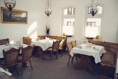 バート・ザルツンゲンにあるPension Morgenweckのレストラン内のダイニングルーム(テーブル2台、椅子付)