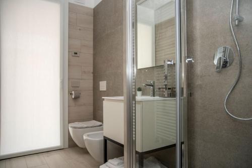 ein Bad mit einer Dusche, einem WC und einem Waschbecken in der Unterkunft Camelot Red - Appartamenti in Verona