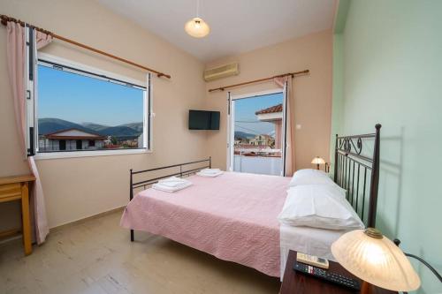 a bedroom with a bed and a large window at Vasilakis Apartment in Sami