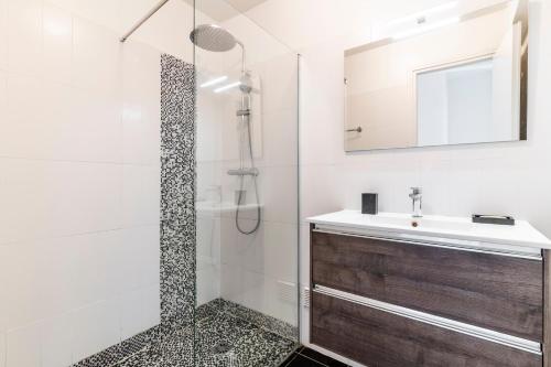 une salle de bain avec une douche, un lavabo et un miroir dans l'établissement Le Mistral - Appt avec deux balcons à Cannes, à Cannes