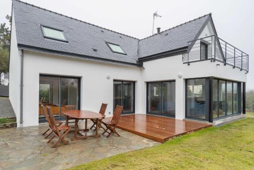 une maison avec une terrasse et une table dans l'établissement Malachappe - Maison pour 8, à Moëlan-sur-Mer