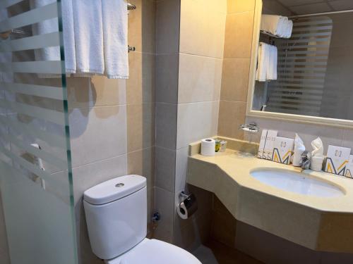 a bathroom with a toilet and a sink at Al Massa Bader Hotel in Mecca