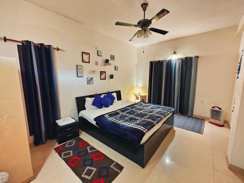 a bedroom with a bed and a ceiling fan at Meraki - Entire 3BHK Villa With Himalayan Views in Rānīkhet