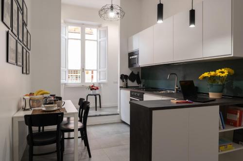 a kitchen with white cabinets and a table with chairs at Veniero37 Guest House in Rome