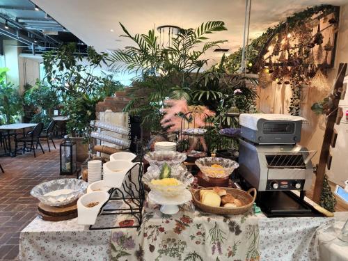 a buffet of food on a table in a room with plants at Staz Hotel Premier Dongtan in Hwaseong