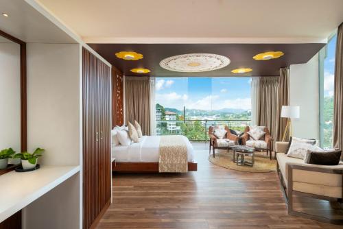 a bedroom with a bed and a large window at Grand Serendib Hotel in Kandy