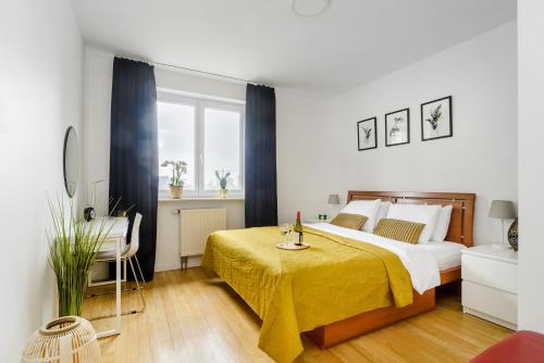 sypialnia z dużym łóżkiem i żółtym kocem w obiekcie Lumina 3 bedroom apart Park Szczęśliwicki w Warszawie