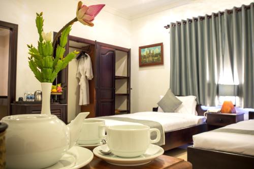 a hotel room with two beds and a table with tea cups at Angkor Tempora Boutique in Siem Reap