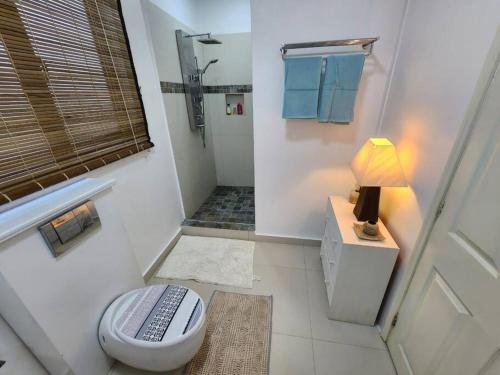 a bathroom with a toilet and a shower with a lamp at Le Choix- Zil in Grand-Baie