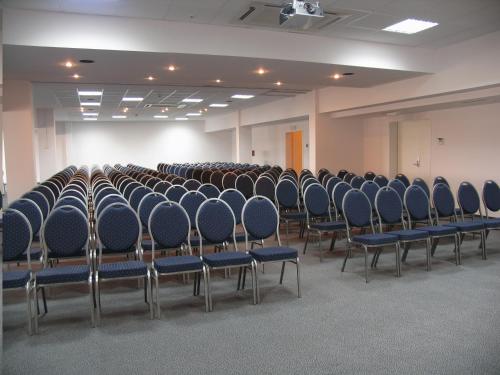 an empty room with rows of chairs in it at Hotel Wodnik in Slok