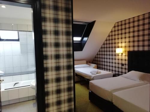 Habitación de hotel con 2 camas y baño en Hotel Clarin, en Oviedo