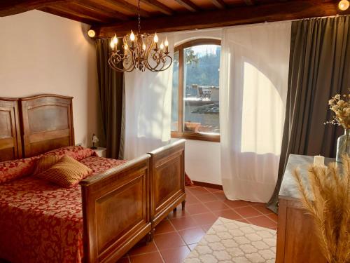 a bedroom with a bed and a window and a chandelier at Agriturismo Il Colle in Poggio Alla Croce