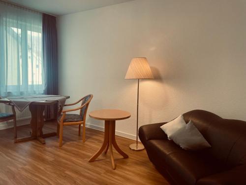 sala de estar con sofá, mesa y lámpara en Serviced Apartments Hohenlohe, 
