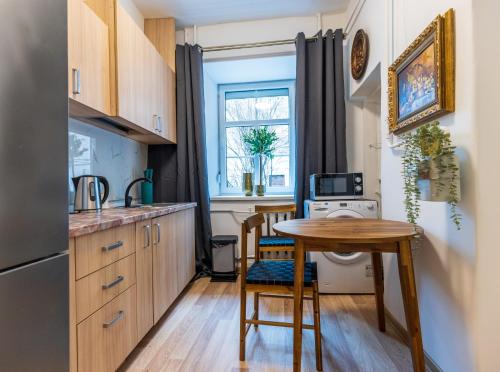 Una pequeña cocina con una mesa y una ventana. en Doma3 Luxury Vilnius Apartment, en Vilna
