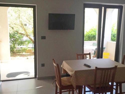 a dining room with a table and chairs and a television at Apartments Cintya in Poreč