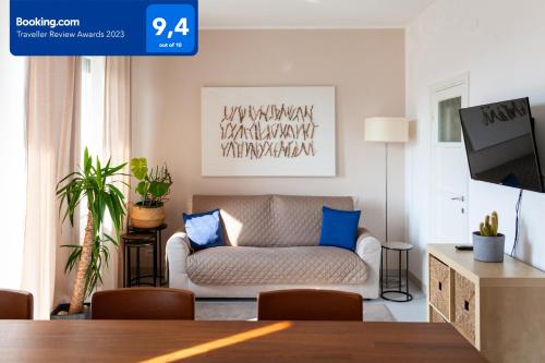 uma sala de estar com um sofá e uma televisão em Sunset House - Smart House - Milano MiCo em Milão