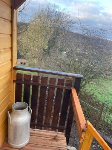 a large pot sitting on the porch of a cabin at La Rouloulotte in Durbuy