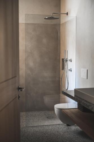 a bathroom with a toilet and a glass shower at Einäugl - Briol in Barbiano
