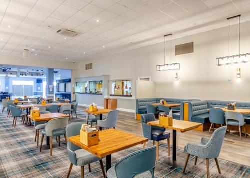 a dining room with tables and chairs and benches at North Devon Resort in Ilfracombe