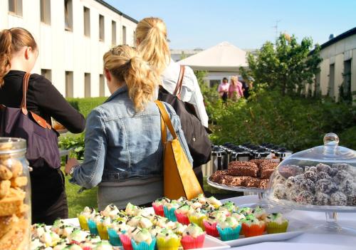 a group of people standing around a table with food at ProfilHotels Hotel Garden in Malmö