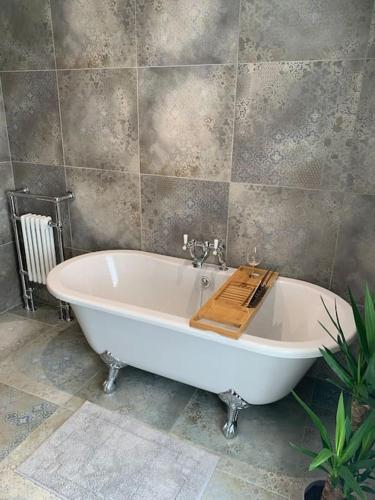 a bath tub with a wooden board on it in a bathroom at Cosy Bay Cottage in Scarborough