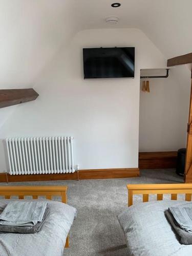 a room with two beds and a tv on the wall at Cosy Bay Cottage in Scarborough