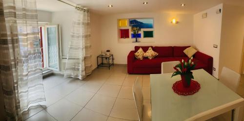 sala de estar con sofá rojo y mesa en Casa Marilisa, en Maiori