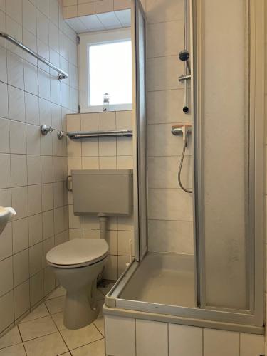 a bathroom with a toilet and a glass shower at Strandhaus am Kurpark in Cuxhaven