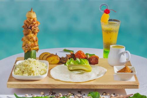 a wooden tray with food and a drink on a table at KHAS Gresik in Gresik