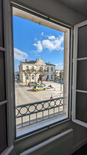 a window with a view of a building at Hôtel Restaurant Le Lion d'Or in Gémozac