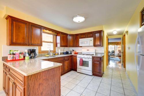 a kitchen with wooden cabinets and white appliances at Oak Lawn Apartment about 2 Mi to Ford City Mall! in Oak Lawn