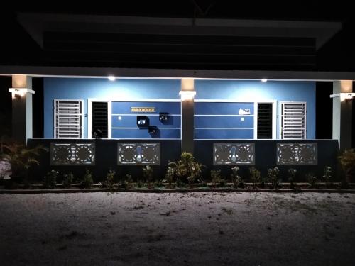 une maison bleue éclairée la nuit dans l'établissement Sacha Homestay, à Baling