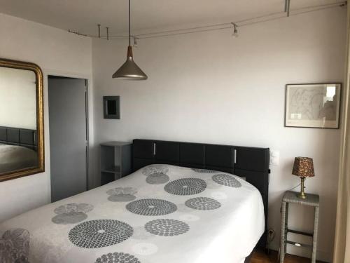 a bedroom with a bed with a black and white comforter at La Caravelle au plus près de la mer in Saint Malo